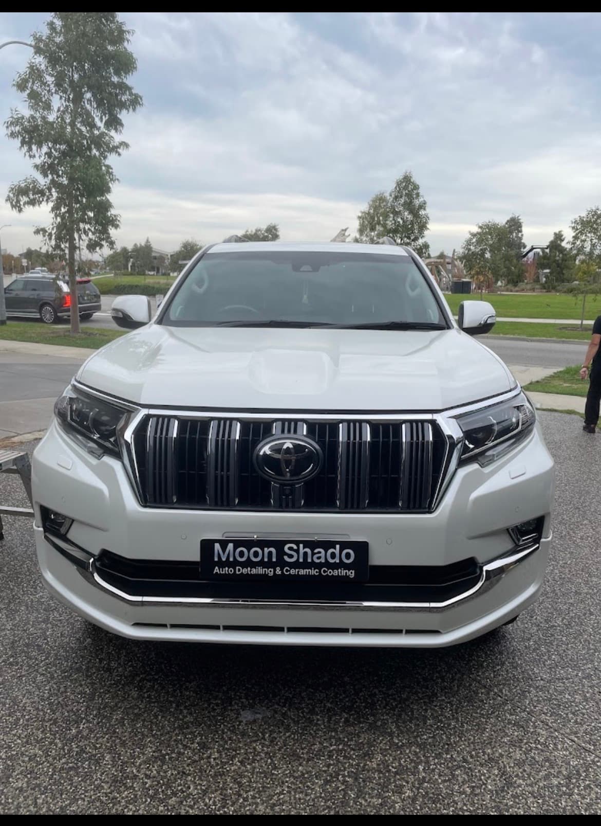 Shiny white Toyota Land Cruiser Prado featuring a Moon Shado auto detailing and coating plate.